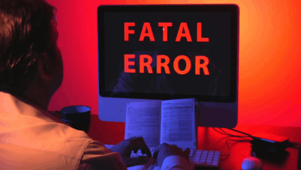 Une personne devant un ordinateur qui affiche un message d'erreur.